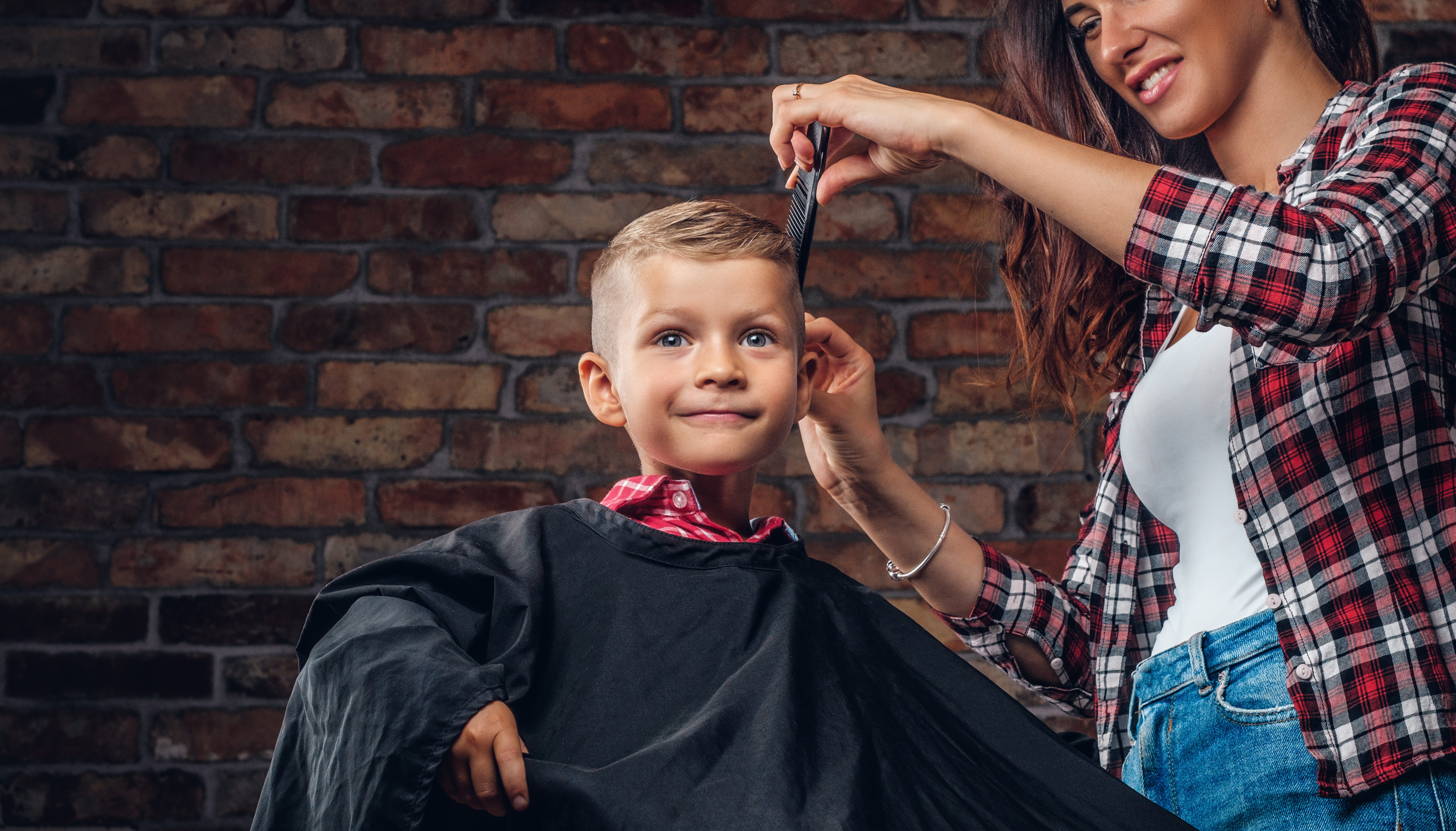 smiling-preschooler-boy-getting-haircut-children-hairdresser-with-scissors-comb-is-cutting-little-boy-room-with-loft-interior